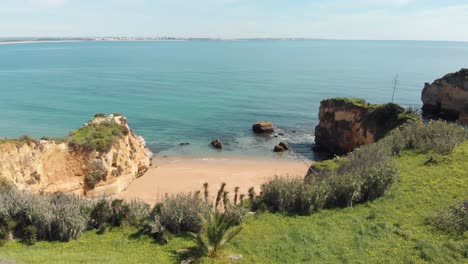 prístina orilla del océano turquesa que baña la costa dorada en lagos algarve, portugal - amplia toma panorámica