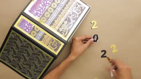 Gluing-gold-foil-numbers-to-put-on-decorated-year-planner-binder-cover