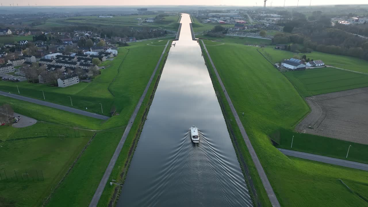 Aerial zoom out showing a boat traveling along the elevated canal in Strépy-Thieu, Le Roeulx at golden hour