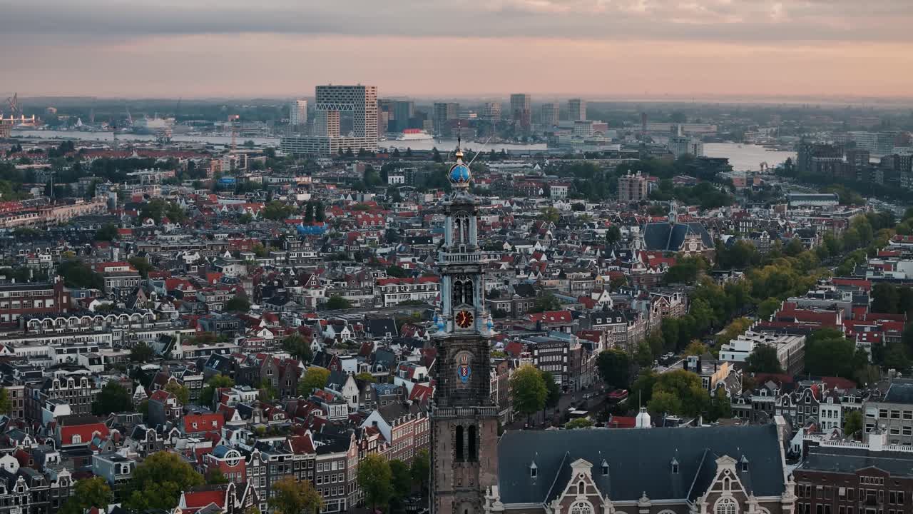 Sunrise circle around a church reveals rooftops and glowing Amsterdam skyline