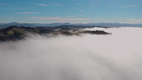 Traumhaftes-Panorama,-Seitwärts-Fliegend-über-Einem-Nebelmeer-Mit-Sanften-Hügeln-Im-Hintergrund