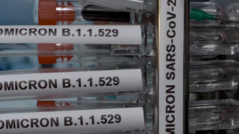 close up vertical dolly shot of omicron b.1.1.529 laboratory samples being placed into a rack, the new deadly variant of covid 19 identified in south africa