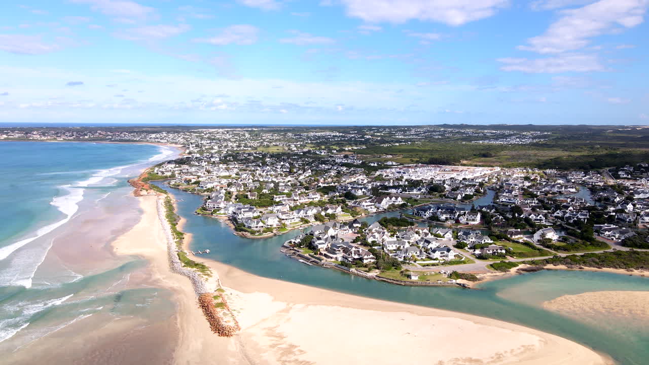 Famous St Francis Bay holiday town with white sand beach and breakwater and properties along Marina Glades canals on Eastern Cape shoreline, aerial view
