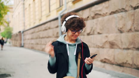 young woman walking and listening to music on the street