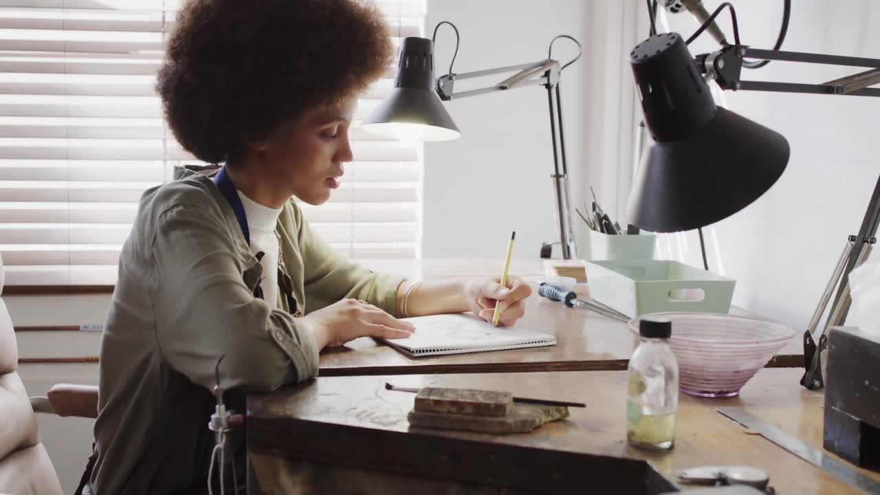 trabajadores diversos felices haciendo joyas artesanales con herramientas en el estudio de joyas en cámara lenta