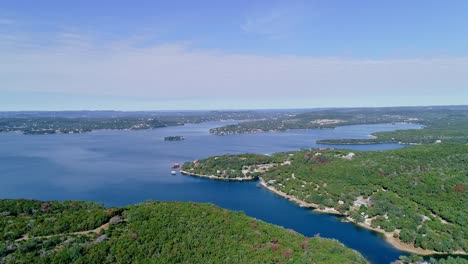 drone footage descending from a beautiful blue sky down towards the lake and trees below, lake medina texas