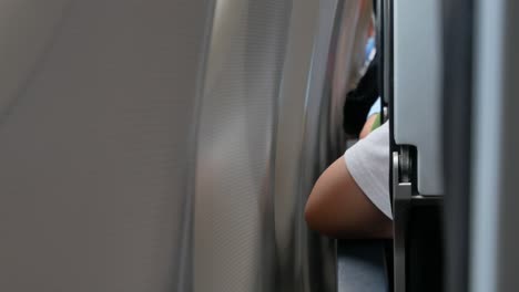 arm rest on armrest while sitting in airplane near window seat
