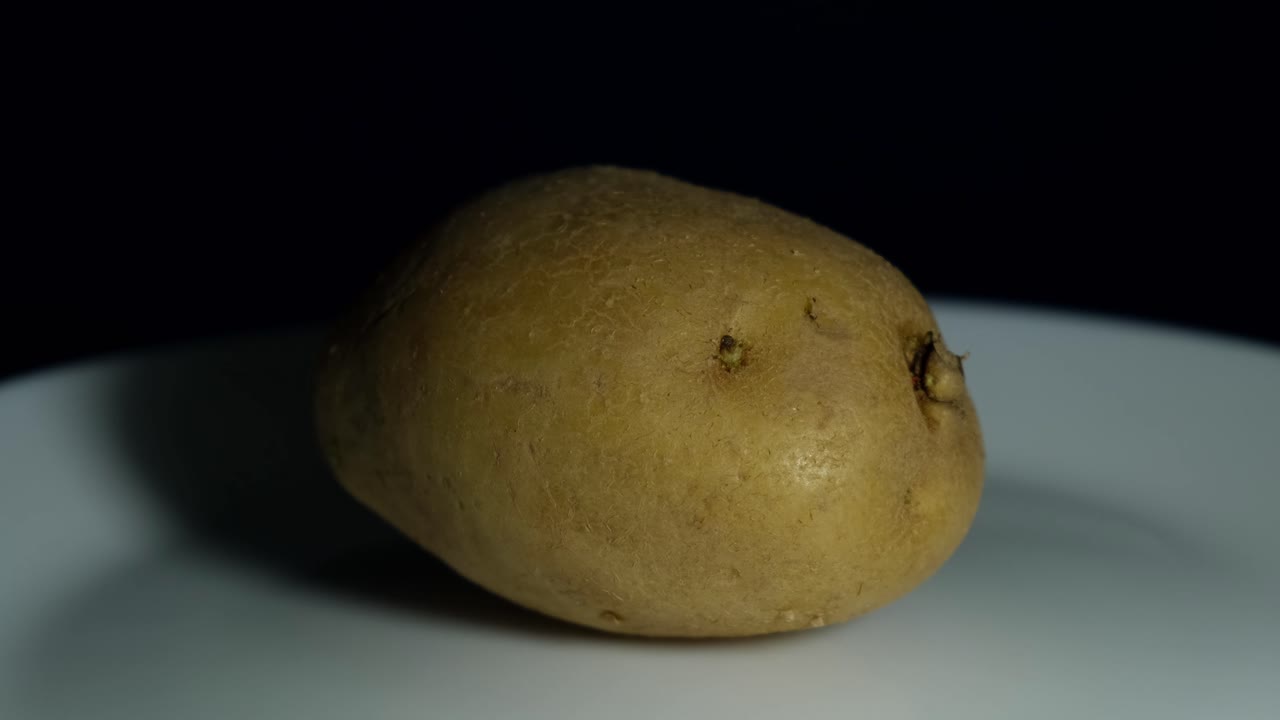 patata en un plato proyectando sombra a la izquierda mientras está en un plato mientras la amera se aleja
