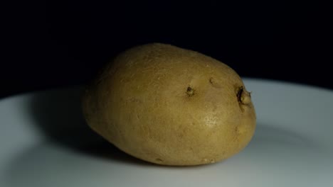 patata en un plato proyectando sombra a la izquierda mientras está en un plato mientras la amera se aleja