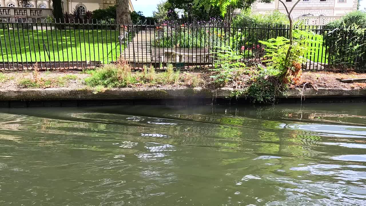 un pato nada a lo largo de un canal en londres