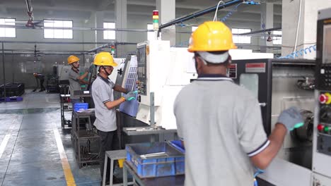factory workers operating industrial machinery