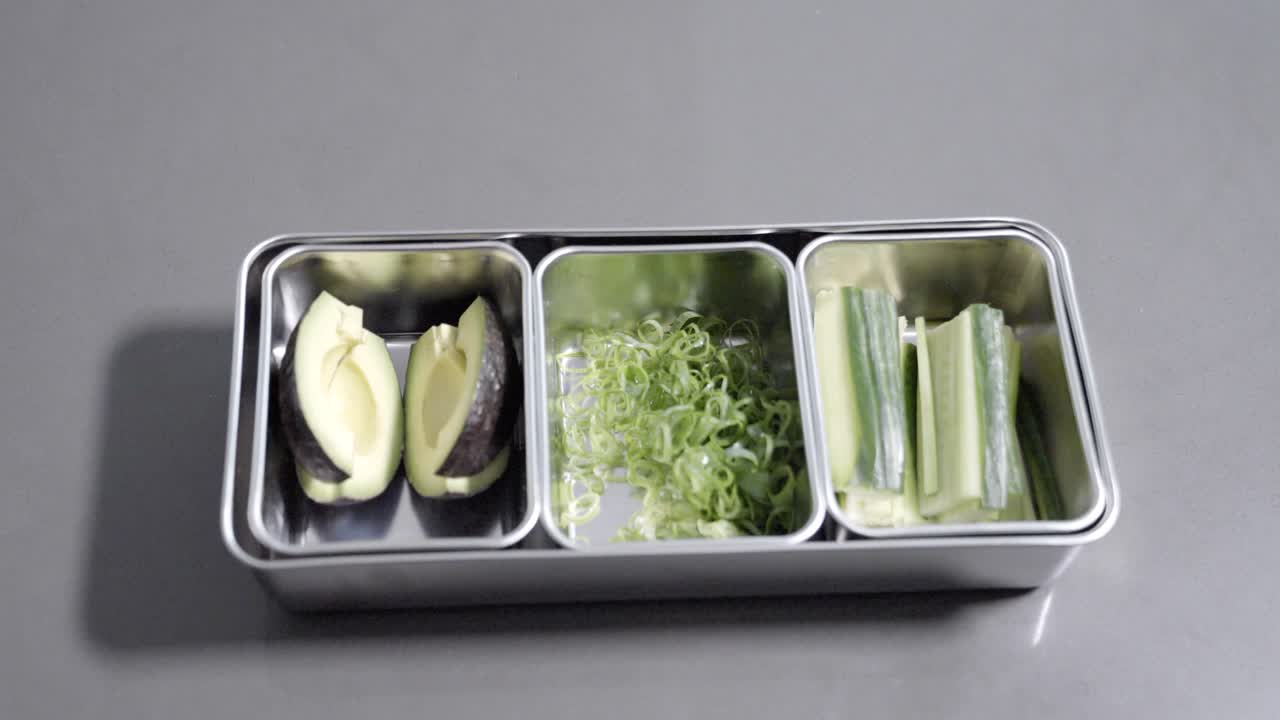 A static, top-down shot captures vegetables being packed and then removed from the frame, filmed at 120 fps to highlight smooth, detailed motion.