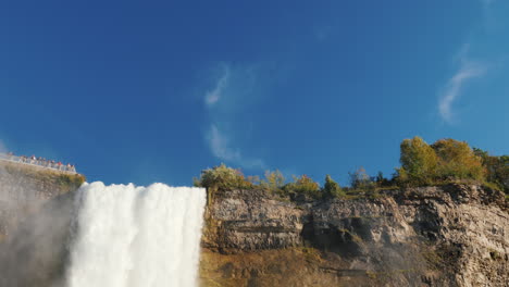 tourists visit niagara falls on a sunny day