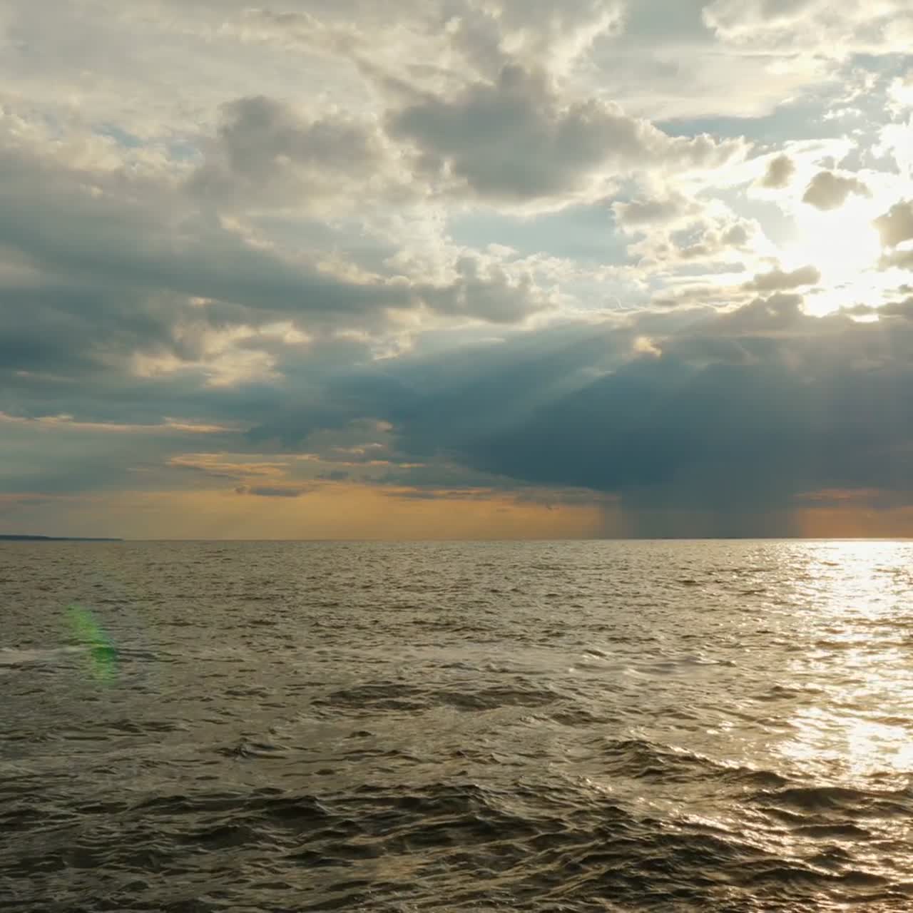 바다 위에 비가 내리는 비구름과 아름다운 광선이 있는 석양 1