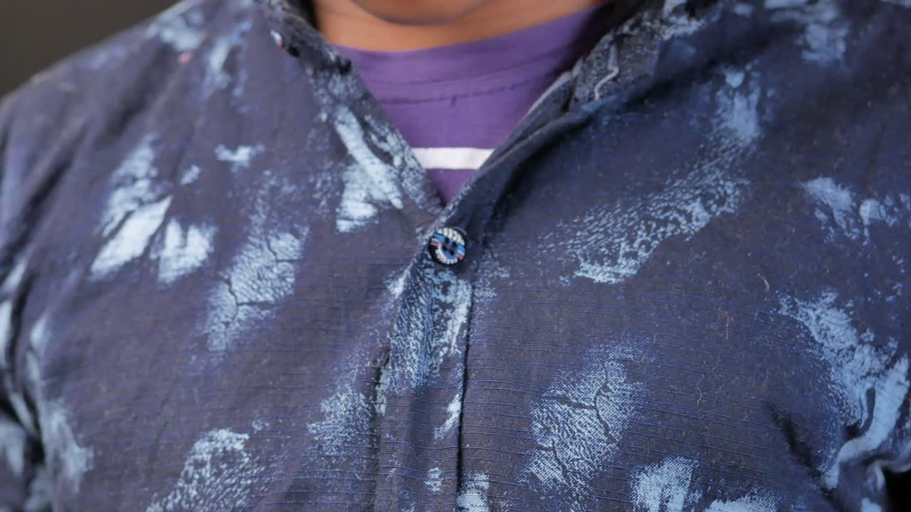 persona abotonando una camisa