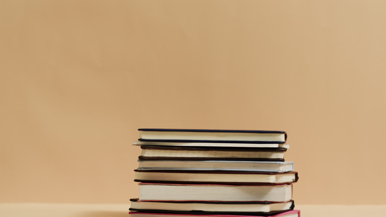 Close up of stack of books with copy space on yellow background