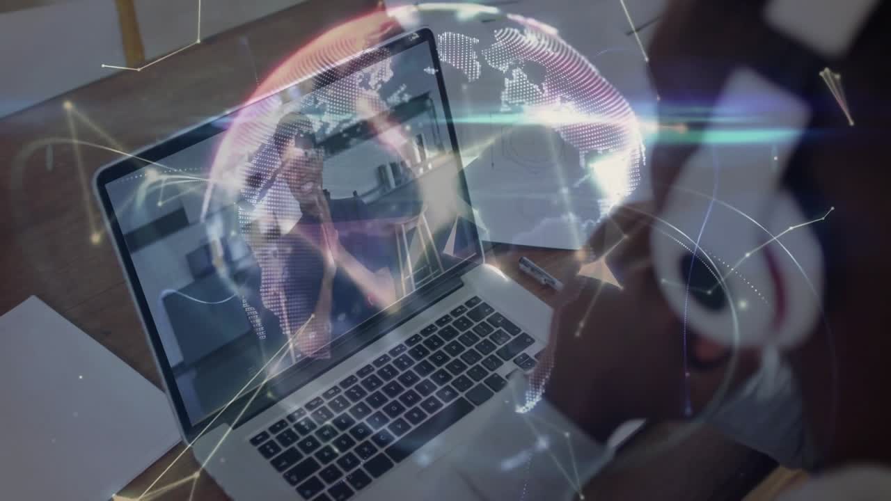 Mand justerer hovedtelefoner og starter tech-møde på bærbar, kvinde klapper, og et overlay danner en globus.