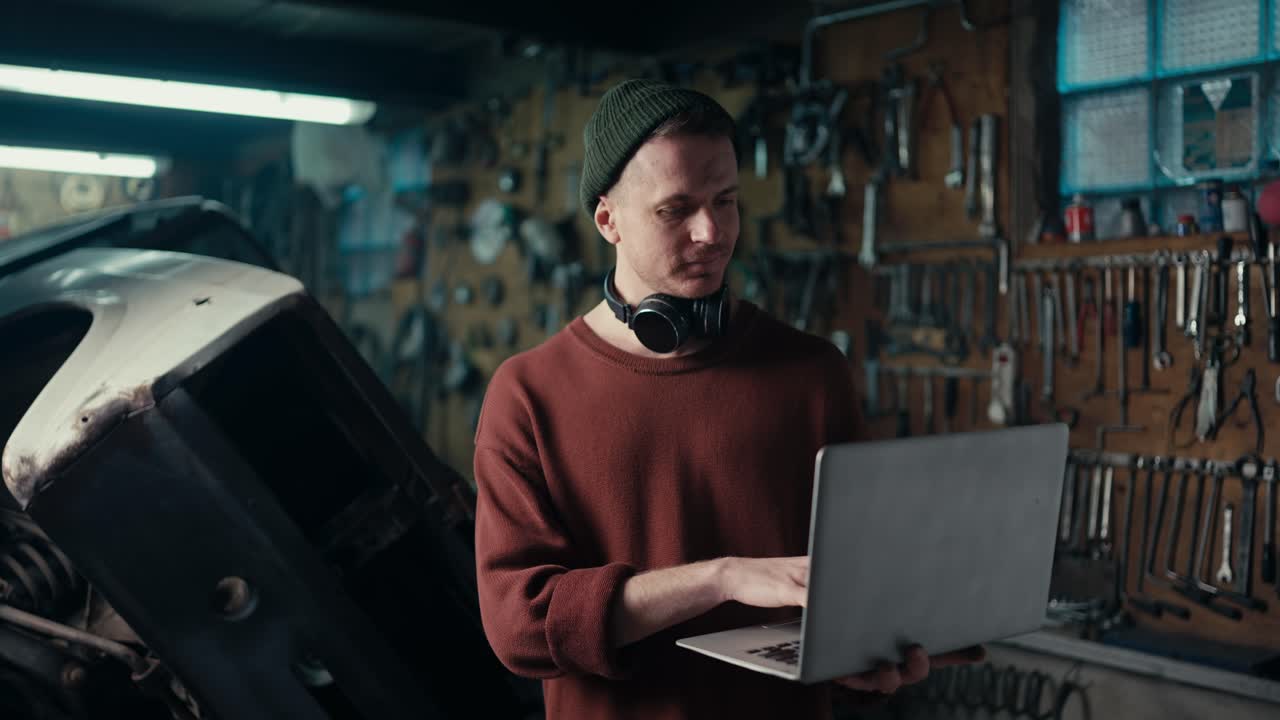 Mastering Productivity: Skilled Professional in Brown Sweater and Green Hat Working on Laptop