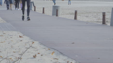 a man runs along the beachfront boardwalk among passersby