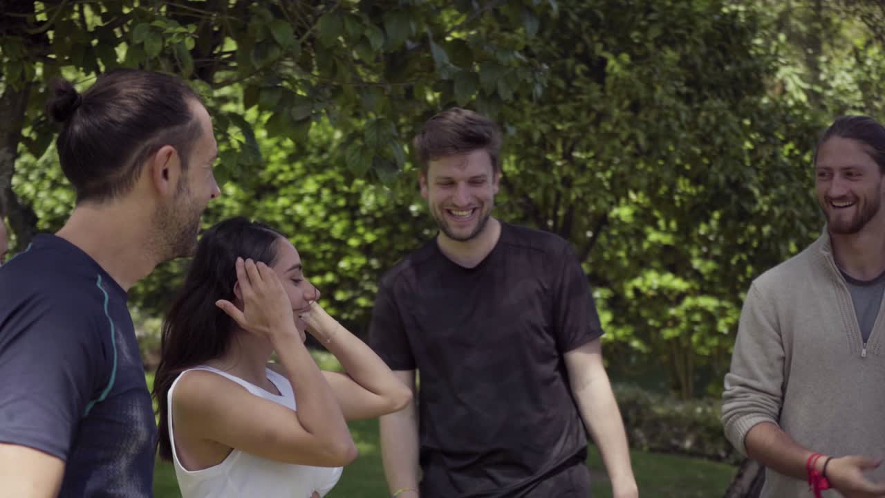 amigos felices masculinos y femeninos saludándose entre sí al aire libre