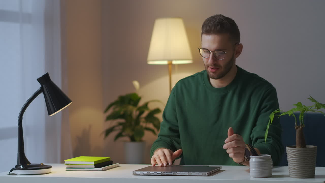 hombre agotado está terminando el trabajo con la computadora portátil por la noche en casa cerrando el cuaderno y quitándose las gafas frotando las sienes dolor de cabeza y fatiga
