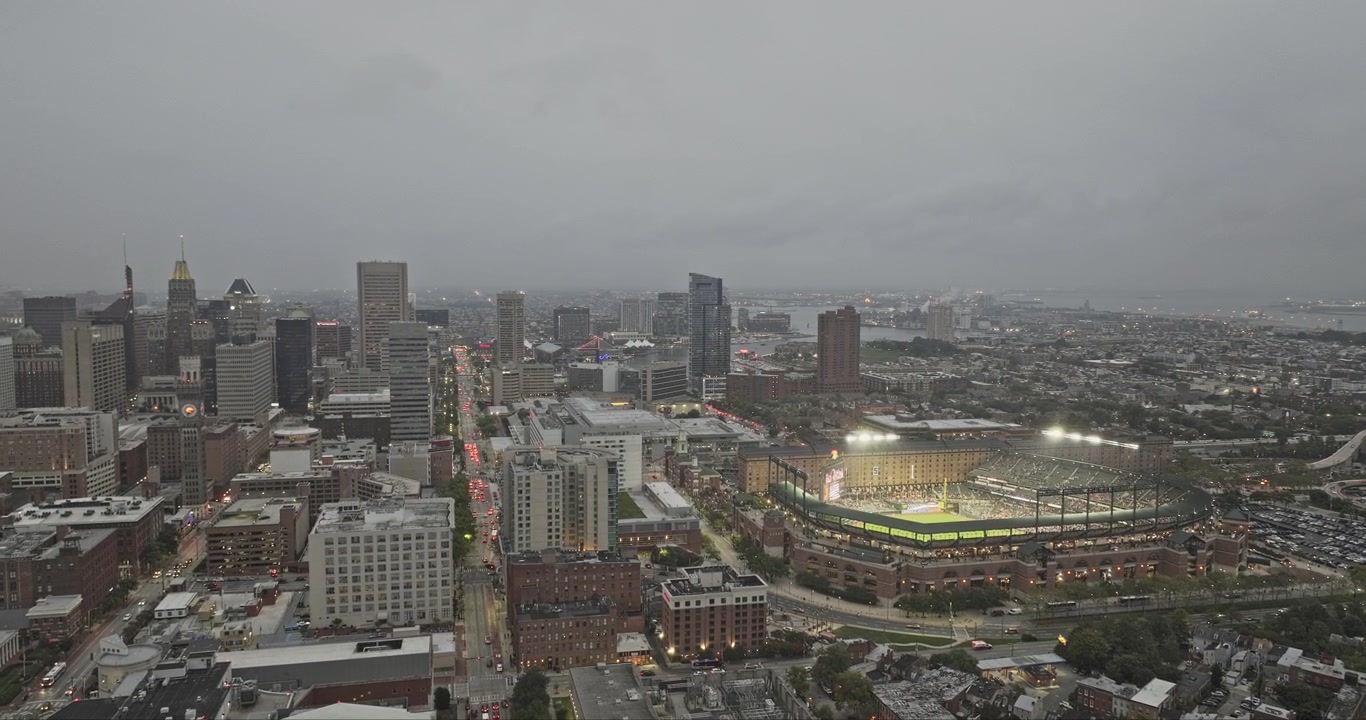 Aérea de Baltimore Maryland v97: sobrevoo sobre Barre Circle, revelando Inner Harbor, o centro da cidade e o estádio Camden Yards sob céus nublados ao anoitecer - Filmado com Mavic 3 Pro Cine - 28 de setembro de 2023