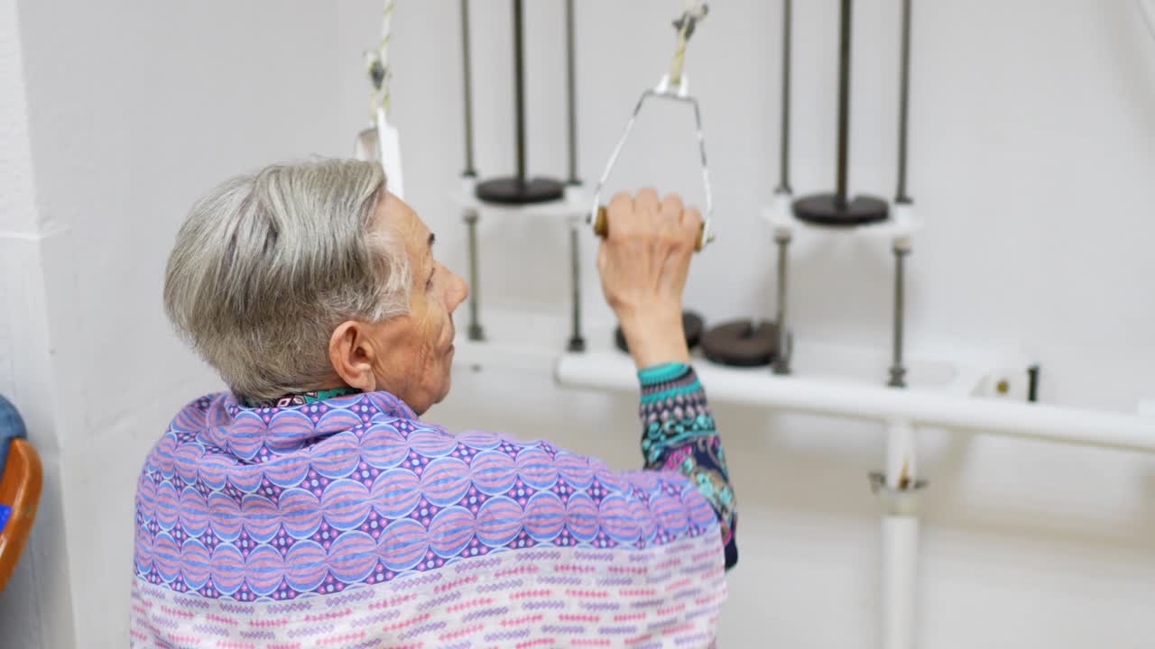 Elderly Woman Engaged in Rehabilitation Exercise with Pulley System