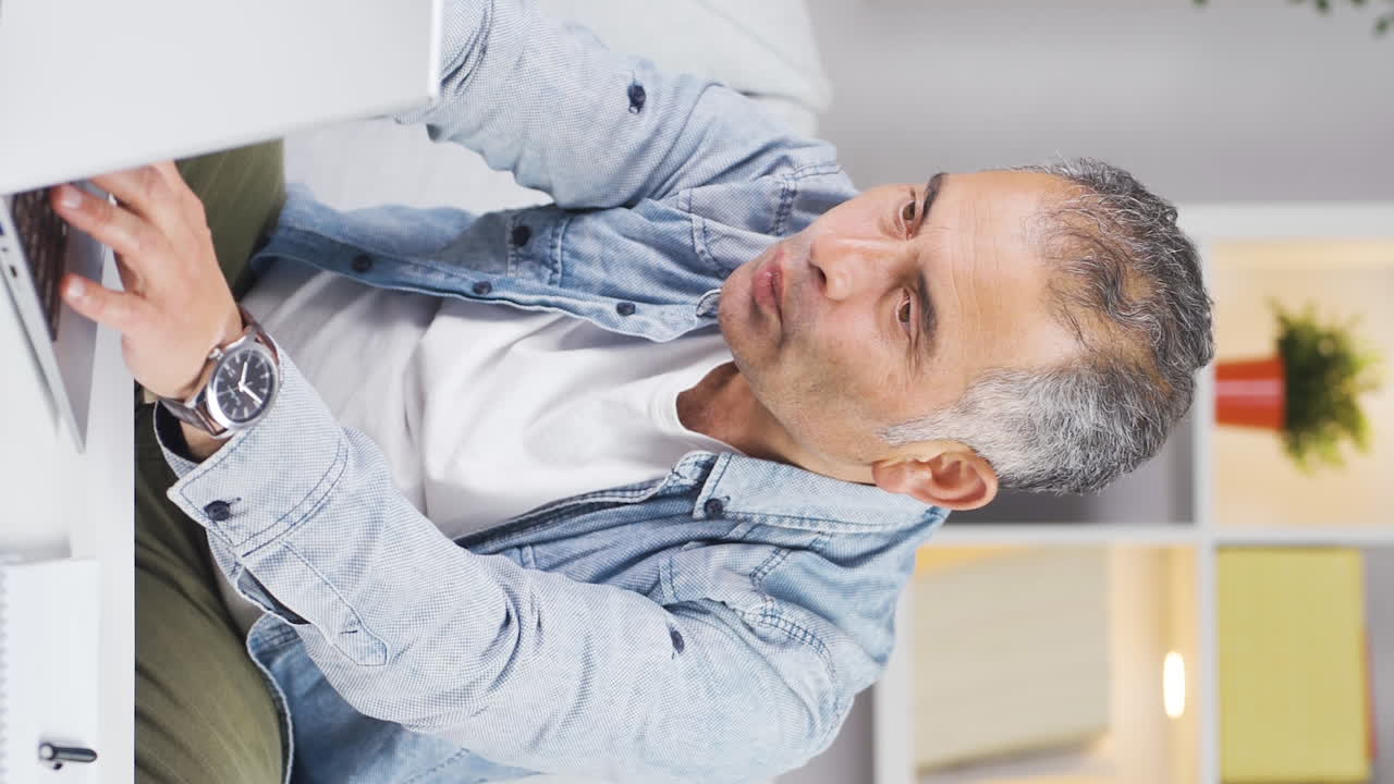 el video vertical del hombre que le gusta la aplicación en la computadora portátil es feliz.