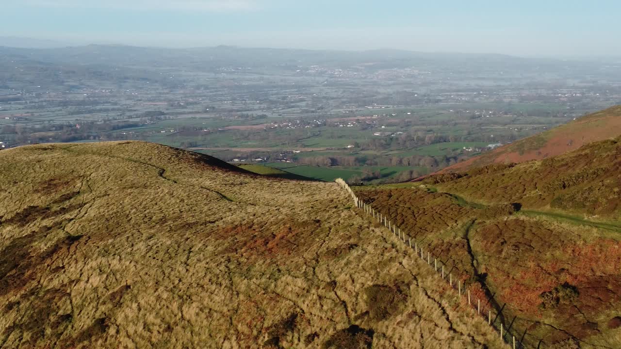 la primera luz del sol en el pico de la montaña de las tierras altas vista aérea a través de vastas tierras de cultivo idílicas y heladas campos panorámicos a la derecha