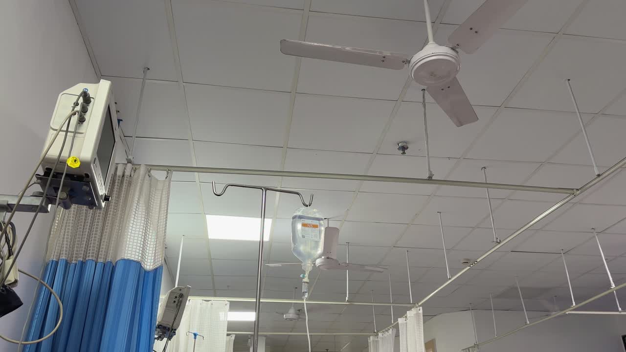Una ripresa in soggettiva dalla prospettiva di un paziente in un letto d'ospedale che mostra il soffitto e il ventilatore
