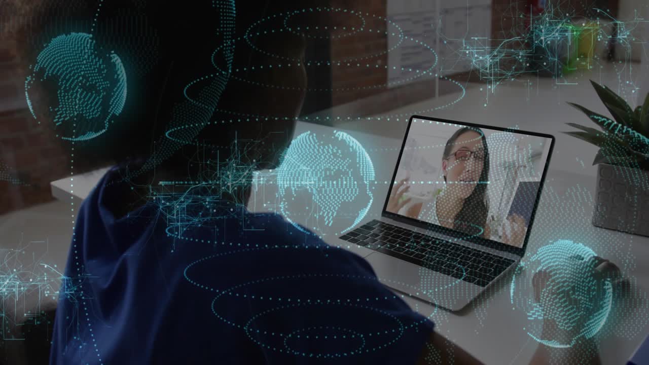 Sedící žena přijímá technický hovor, naklání se k notebooku a pracuje s pohybujícím se holografickým glóbem