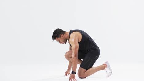 athlete in starting position ready to sprint, with copy space on white background