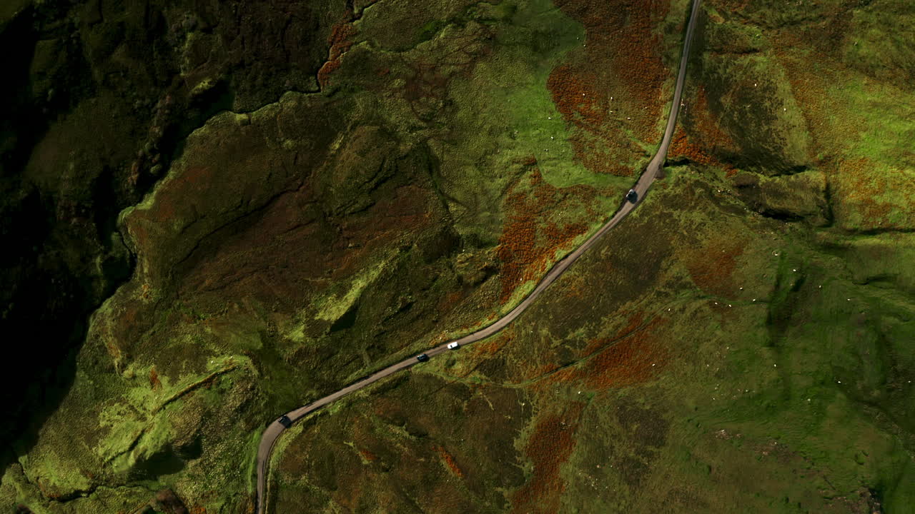 Vehicles Driving On Winding Road Through Colorful Slopes Of Quiraing. Isle Of Skye, Scotland, UK. aerial topdown shot