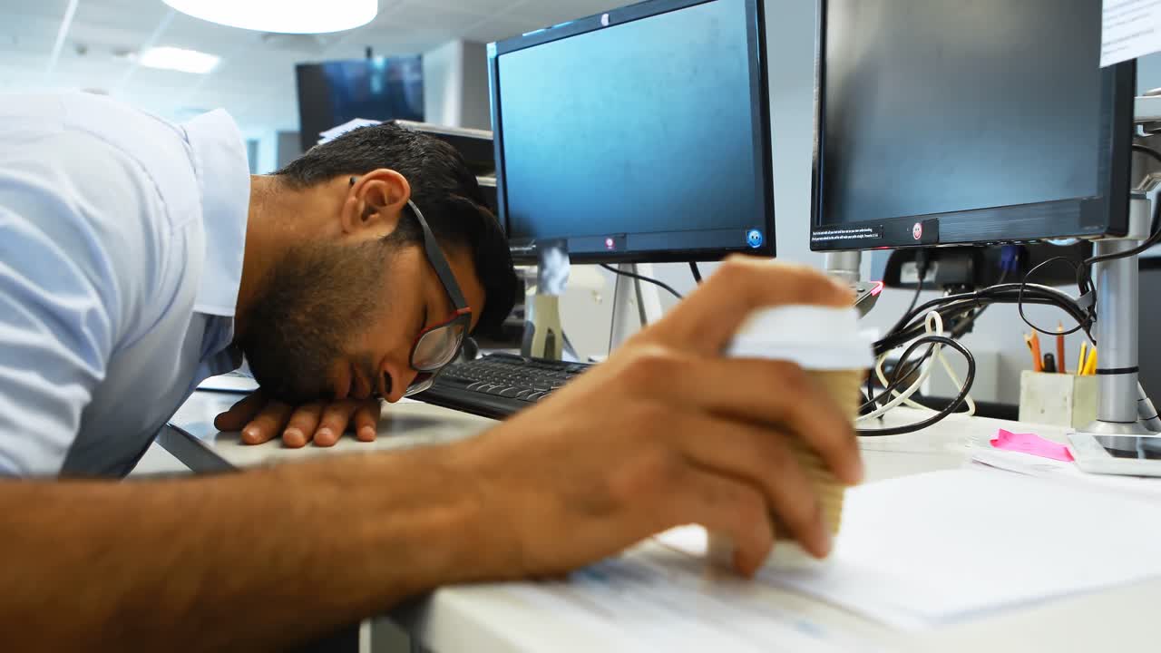 Male executive sleeping at desk
