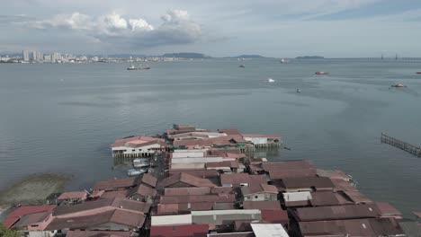 chew jetty: buildings on stilts on malaysian city waterfront, aerial