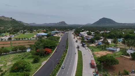 Aerial-footage-of-wind-turbines-located-near-the-highway,-showcasing-renewable-energy