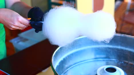 women is hands are preparing cotton candy in park