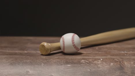 Nahaufnahme-Eines-Studio-Baseball-Stilllebens-Mit-Holzschläger-Und-Ball-Auf-Holzboden