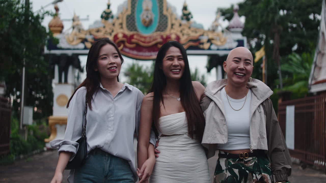 Three Women Walking Together on a Street
