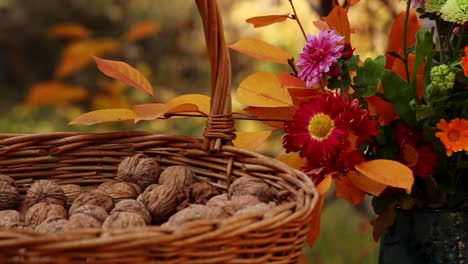 Cesta-De-Mimbre-Con-Nueces-Junto-A-Un-Jarrón-De-Flores-En-La-Mesa-Exterior