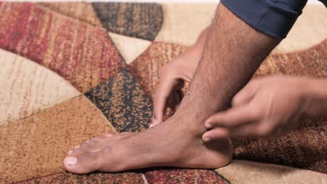 man massaging his painful ankle