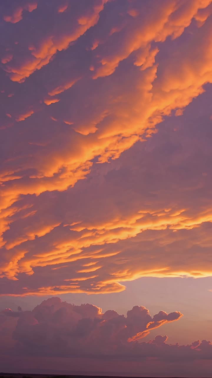 Dramatic sunset clouds fill the sky, captured from a low angle, creating a cinematic video effect