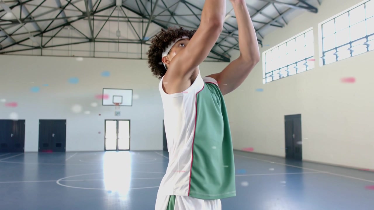 Atleta uomo che cambia la presa, si esercita nel tiro libero mentre coriandoli animati tracciano l'arco del tiro.