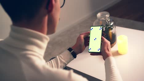 Relaxed-young-man-using-smart-phone-with-green-screen-chroma-key