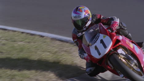 a motorcycle racer leans into a sharp turn 1