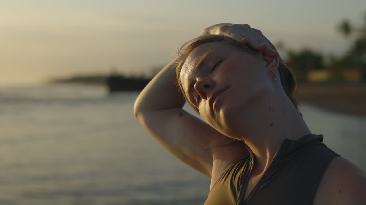 해가 지면 해변에서 휴식을 취하는 여자