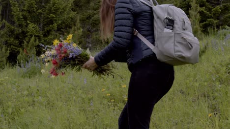 mujer recogiendo flores silvestres bajo una lluvia ligera