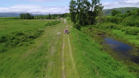 Top-View-of-A-Farm-Truck-Driving-On-The-Green-Field-In-Oregon,-United-States