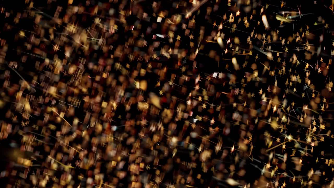 Złote cząsteczki unoszą się w ciemnej przestrzeni, uchwycone w zbliżeniu, idealne jako tło do wideo.