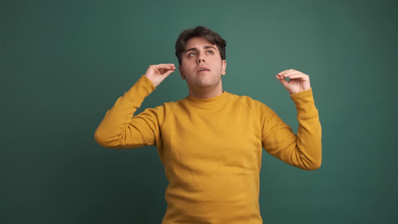 Upset man making blah blah gesture in green studio